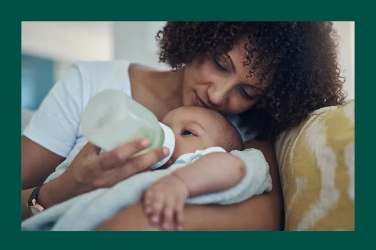 Young mother feeding her infant with a bottle