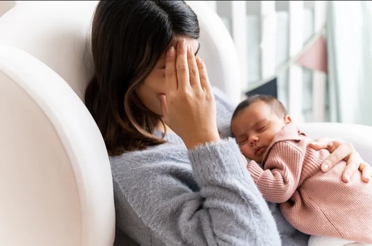 Mother with newborn baby sleeping on her
