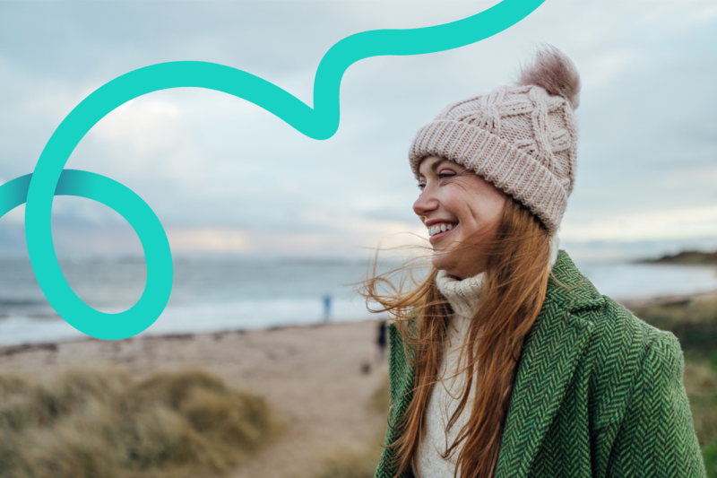 Young woman walking on the beach in the cold
