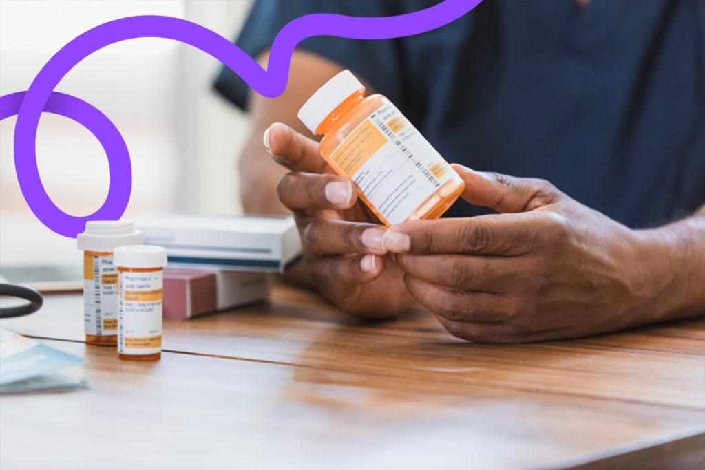 Man holding prescriptions at the table
